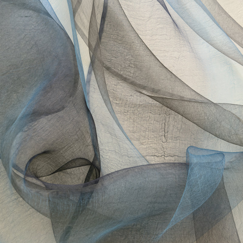 Close-up of fabric. Hand-painted silk scarf by Otta-Italy, 50 x 200 cm, featuring gray, midnight blue and blue colors. Luxury Italian silk scarf, soft and lightweight scarf for women and men.
