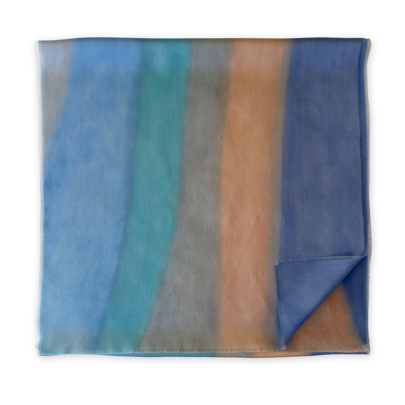 Folded fabric with multicolored stripes on a white background. Silk-scarf-hand-painted-45x180cm-blue-gray-turquoise-otta-italy