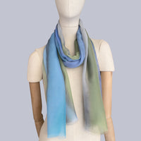 Mannequin wearing scarf on a gray background. Hand-painted silk scarf by Otta-Italy, 65 x 175 cm, featuring 
blue, green and gray. Luxury Italian pure silk accessory, soft, fresh and lightweight scarf for women and men.
