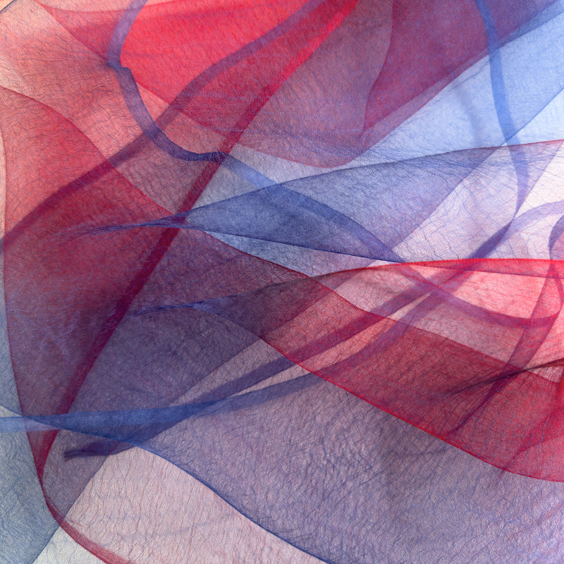 Close-up of fabric. Hand-painted silk scarf by Otta-Italy, 48 x 194 cm, featuring red and blue colors. Luxury Italian silk scarf, soft and lightweight scarf for women and men.
