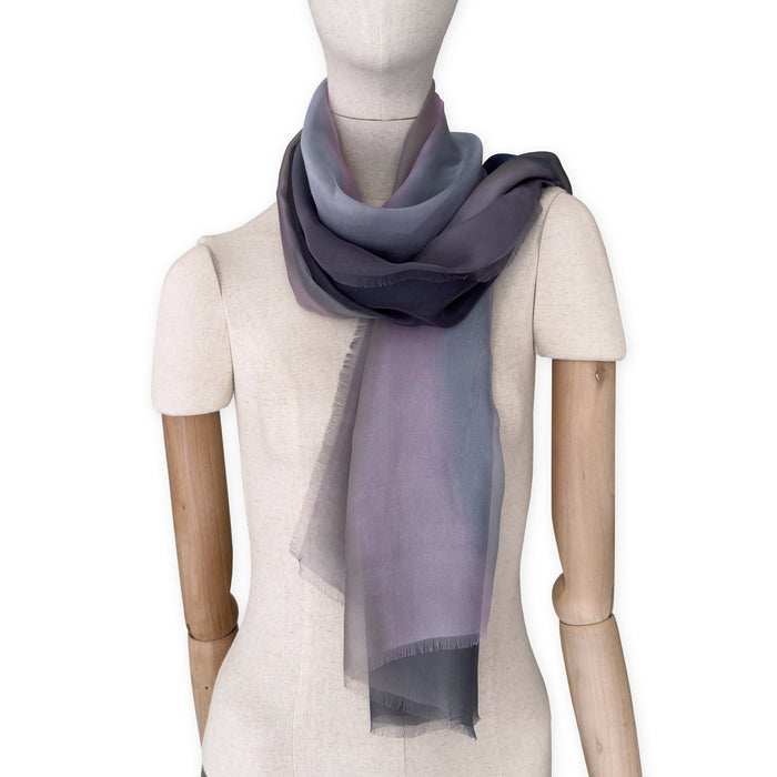 Mannequin wearing a colorful and lightweight silk scarf on a white background. Silk scarf is in shades of gray and pink colors. It is hand-painted scarf in measures 177 x 65 cm by otta-italy scarves brand.

