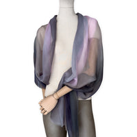Mannequin wearing a colorful and lightweight silk scarf on a white background. Silk scarf is in shades of gray and pink colors. It is hand-painted scarf in measures 177 x 65 cm by otta-italy scarves brand.

