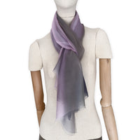 Mannequin wearing a colorful and lightweight silk scarf on a white background. Silk scarf is in shades of gray and pink colors. It is hand-painted scarf in measures 177 x 65 cm by otta-italy scarves brand.
