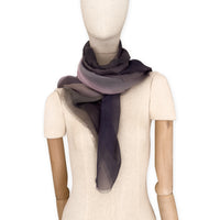 Mannequin wearing a colorful and lightweight silk scarf on a white background. Silk scarf is in shades of gray and pink colors. It is hand-painted scarf in measures 177 x 65 cm by otta-italy scarves brand.
