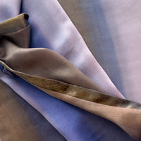 Close-up of fabric. Hand-painted silk scarf by Otta-Italy, 171 x 24 cm, featuring blue, lilac and brown colors. Luxury Italian silk scarf, soft and lightweight scarf for women and men.
