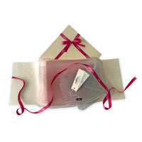 Set of scarves in a gift box with a pink ribbon on a white background. 
Hand-painted silk scarf by Otta-Italy, 50 x 200 cm, featuring 
pink and light gray. Luxury Italian pure silk accessory, soft and lightweight scarf for women and men.

