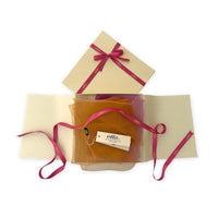 Luxury gift box with a pink ribbon containing a hand-painted Otta pure silk organza scarf on a white background.