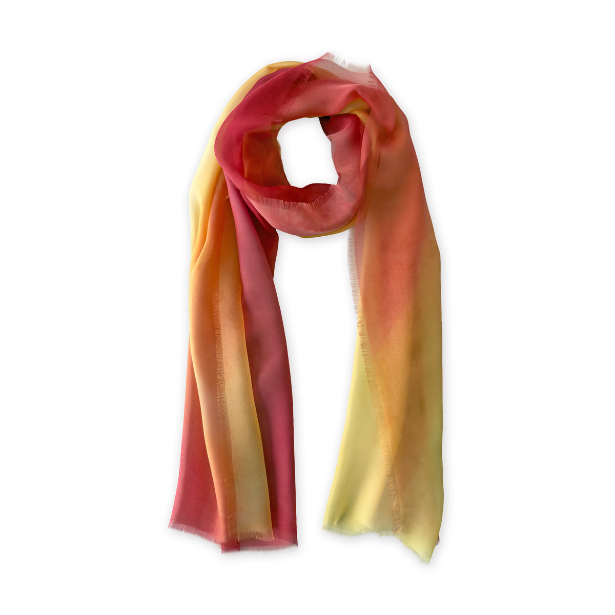 A hand-painted Otta pure silk scarf on a white background, in 
red, orange, fuchsia and yellow shades, loosely looped to showcase its full length and delicate texture. Lightweight artisan accessory with hand-fringed edges, measuring 65 x 175 cm.
