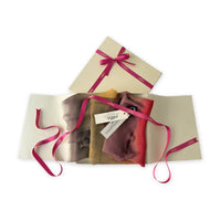 Set of scarves in a gift box with a pink ribbon on a white background. 
Hand-painted silk scarf by Otta-Italy, 176 x 64 cm, featuring red, orange, yellow and brown colors. Luxury Italian silk scarf, soft and lightweight scarf for women and men.