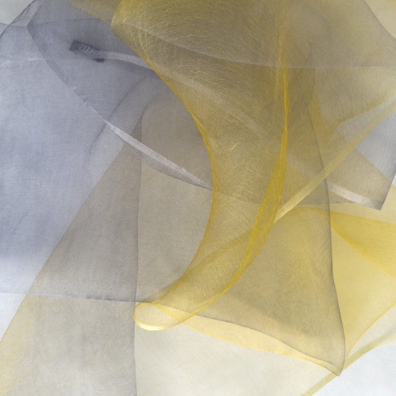 Close-up of fabric. Hand-painted silk scarf by Otta-Italy, 50 x 194 cm, featuring yellow and gray colors. Luxury Italian silk scarf, soft and lightweight scarf for women and men.
