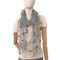 Mannequin wearing an elegant hand-painted Otta-Italy organic silk and wool felted scarf on a white background. Gray and green tones.