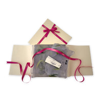  Luxury gift box with a pink ribbon containing a hand-painted Otta-Italy silk organza and wool felted scarf on a white background.