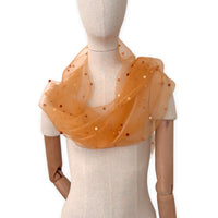 Mannequin wearing a hand-painted Otta pure silk with hand-needle felted wool scarf on a white background in 
orange, peach, beige and brown tones. soft, fresh and lightweight, and elegant accessory measuring 183 x 44 cm. Unique artisan scarf with hand-fringed edges, perfect for women and men.
