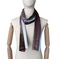 Mannequin wearing a colorful velvet scarf on a white background. Velvet scarf is in shades of brown and blue colors. It is hand-painted scarf in measures 180 x 18 cm by otta-italy scarves brand.
