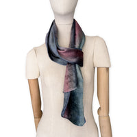Mannequin wearing a colorful velvet scarf on a white background. Velvet scarf is in shades of green, pink and blue navy colors. It is hand-painted scarf in measures 180 x 20 cm by otta-italy scarves brand.
