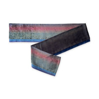 Colorful velvet scarf in green, pink and blue navy shades on a white background. t is hand-painted scarf in measures 180 x 20 cm by otta-italy scarves brand. Luxury Italian velvet accessory, soft and warm scarf for women and men.
