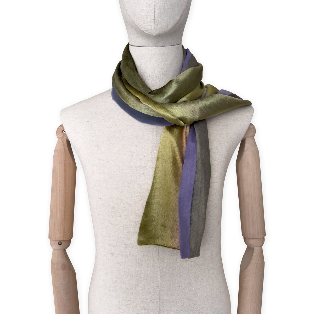 Mannequin wearing a colorful velvet scarf on a white background. Velvet scarf is in shades of green, pink and purple colors. It is hand-painted scarf in measures 185 x 20 cm by otta-italy scarves brand.
