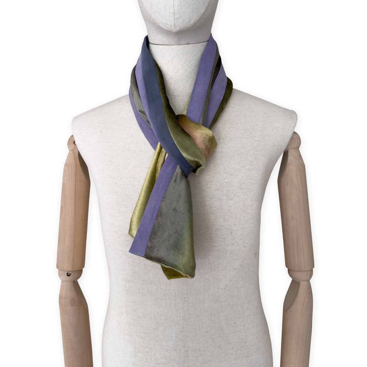 Mannequin wearing a colorful velvet scarf on a white background. Velvet scarf is in shades of green, pink and purple colors. It is hand-painted scarf in measures 185 x 20 cm by otta-italy scarves brand.
