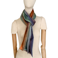Mannequin wearing a colorful velvet scarf on a white background. Velvet scarf is in shades of green, red and purple colors. It is hand-painted scarf in measures 181 x 18 cm by otta-italy scarves brand.
