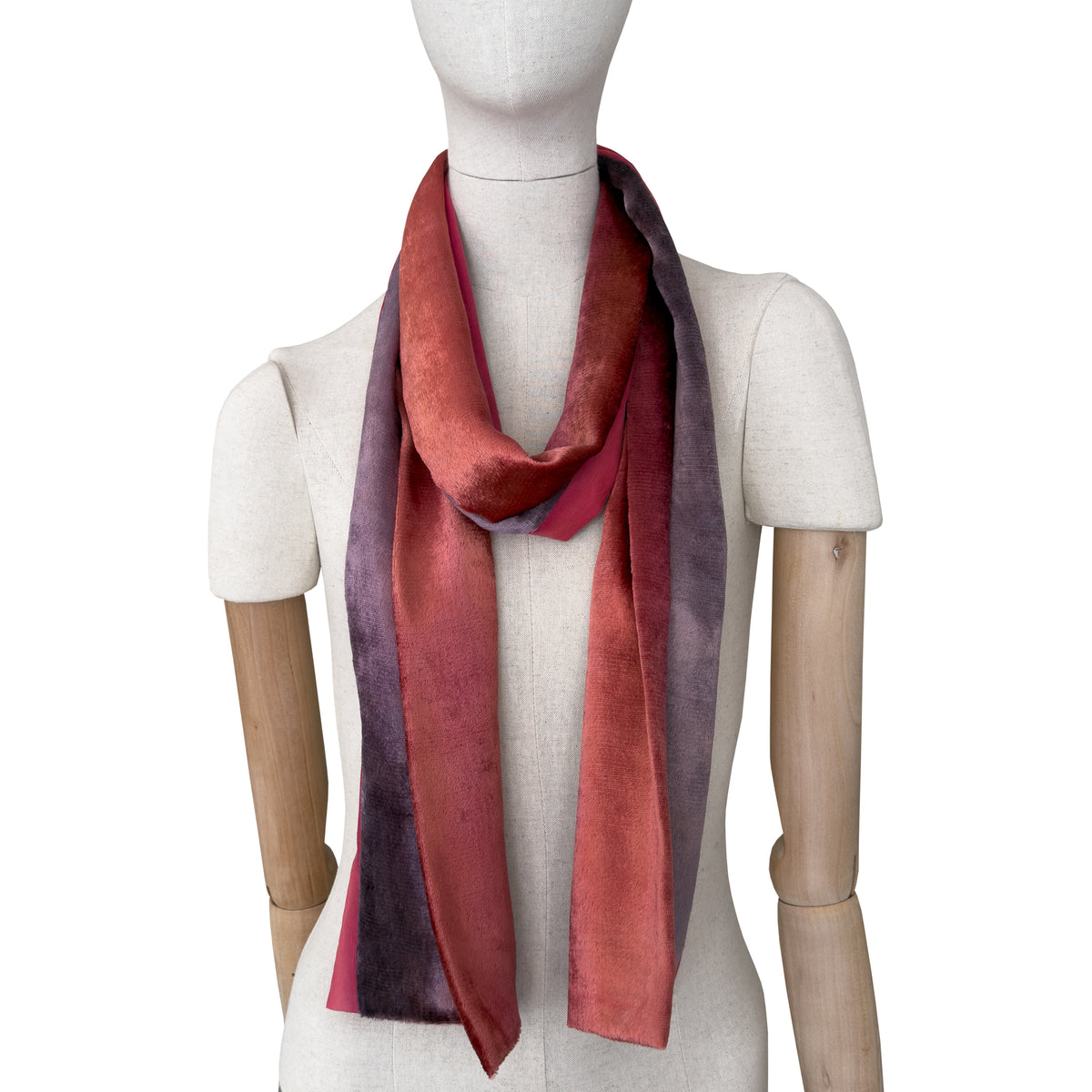 Mannequin wearing a colorful velvet scarf on a white background. Velvet scarf is in shades of red and purple colors. It is hand-painted scarf in measures 184 x 17 cm by otta-italy scarves brand.
