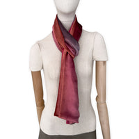Mannequin wearing a colorful velvet scarf on a white background. Velvet scarf is in shades of red and purple colors. It is hand-painted scarf in measures 184 x 17 cm by otta-italy scarves brand.
