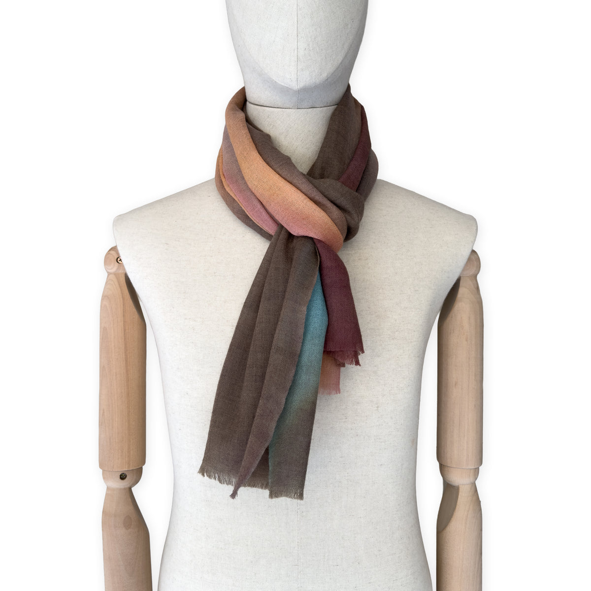 Mannequin wearing scarf on a white background. Hand-painted wool scarf by Otta-Italy, 56 x 177 cm, featuring brown, turquoise, peach colors. Luxury Italian accessory, soft and warm scarf for women and men.
