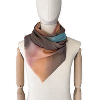 Mannequin wearing scarf on a white background. Hand-painted wool scarf by Otta-Italy, 56 x 177 cm, featuring brown, turquoise, peach colors. Luxury Italian accessory, soft and warm scarf for women and men.
