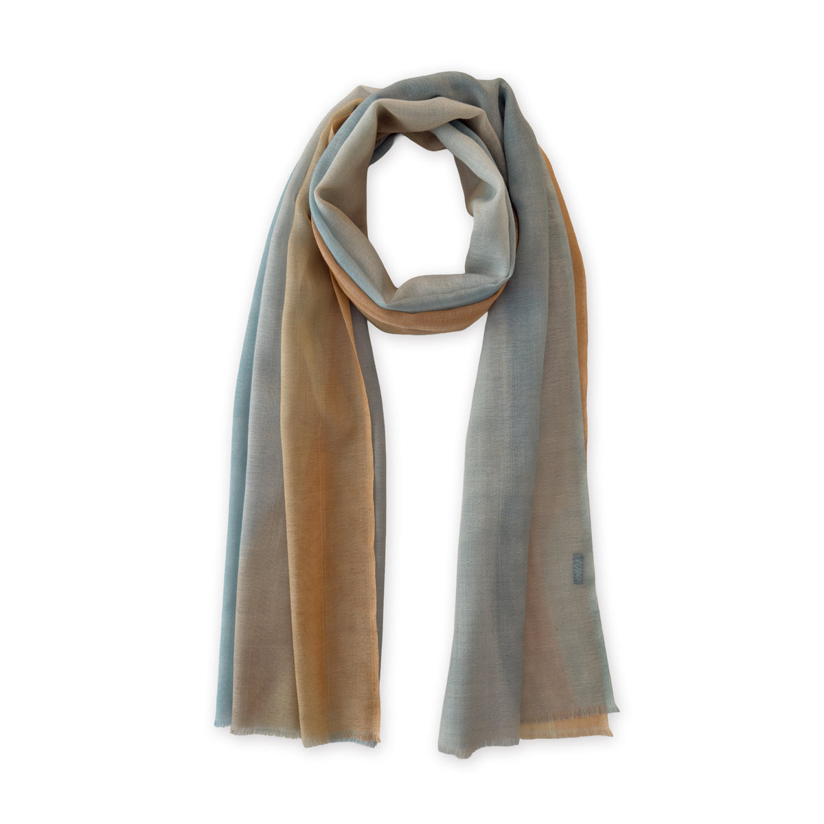 Hand-painted Otta wool scarf in 
blue, gray and ocher, loosely looped to showcase its full length and delicate texture in white background. Lightweight artisan accessory with hand-fringed edges, measuring 61 x 197 cm.
