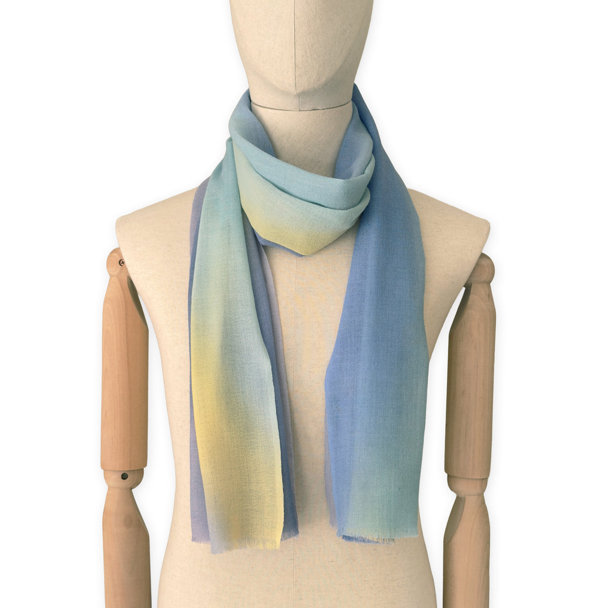Mannequin wearing scarf on a white background. Hand-painted wool scarf by Otta-Italy, 57 x 180 cm, featuring blue, purple, yellow colors. Luxury Italian accessory, soft and warm scarf for women and men.
