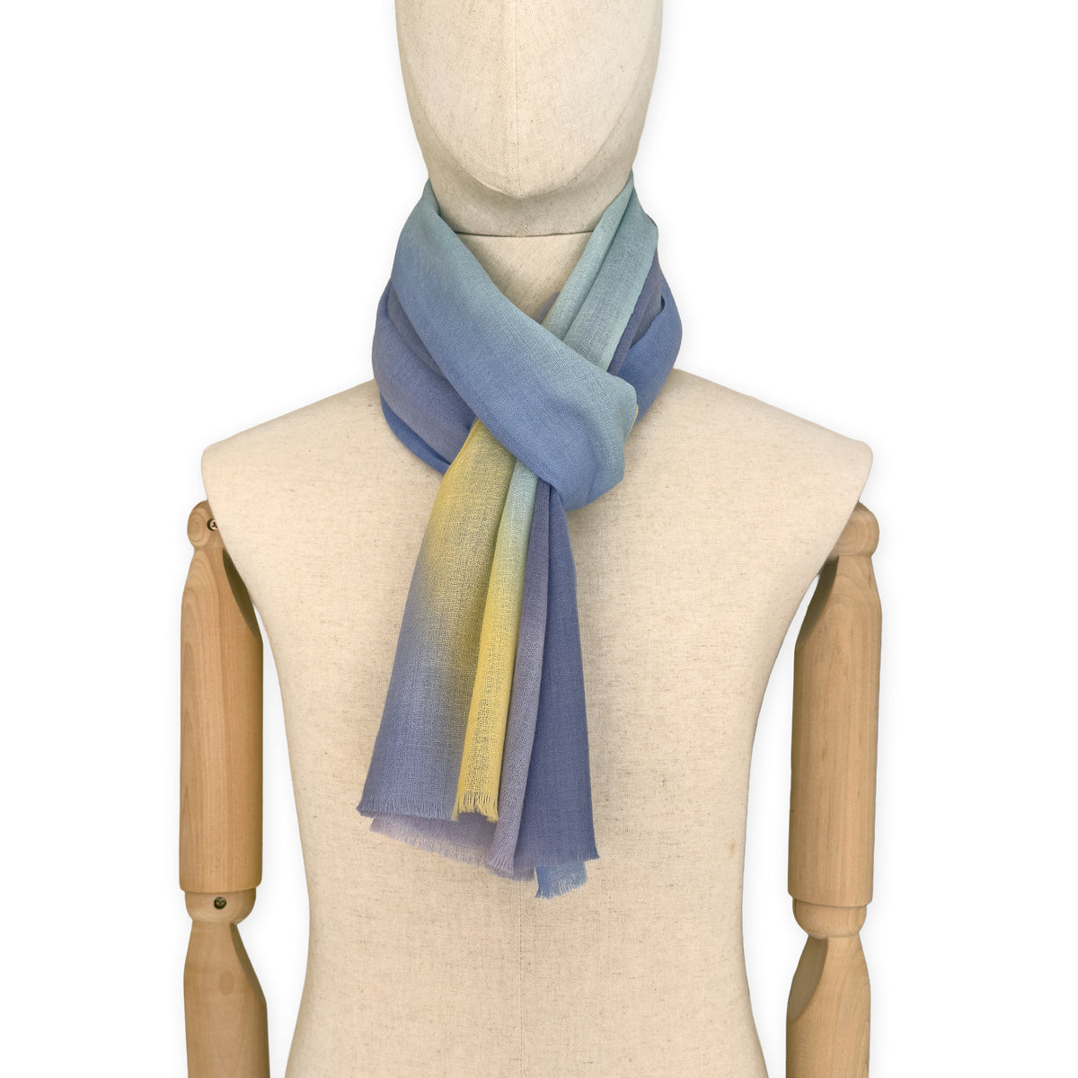 Mannequin wearing scarf on a white background. Hand-painted wool scarf by Otta-Italy, 57 x 180 cm, featuring blue, purple, yellow colors. Luxury Italian accessory, soft and warm scarf for women and men.
