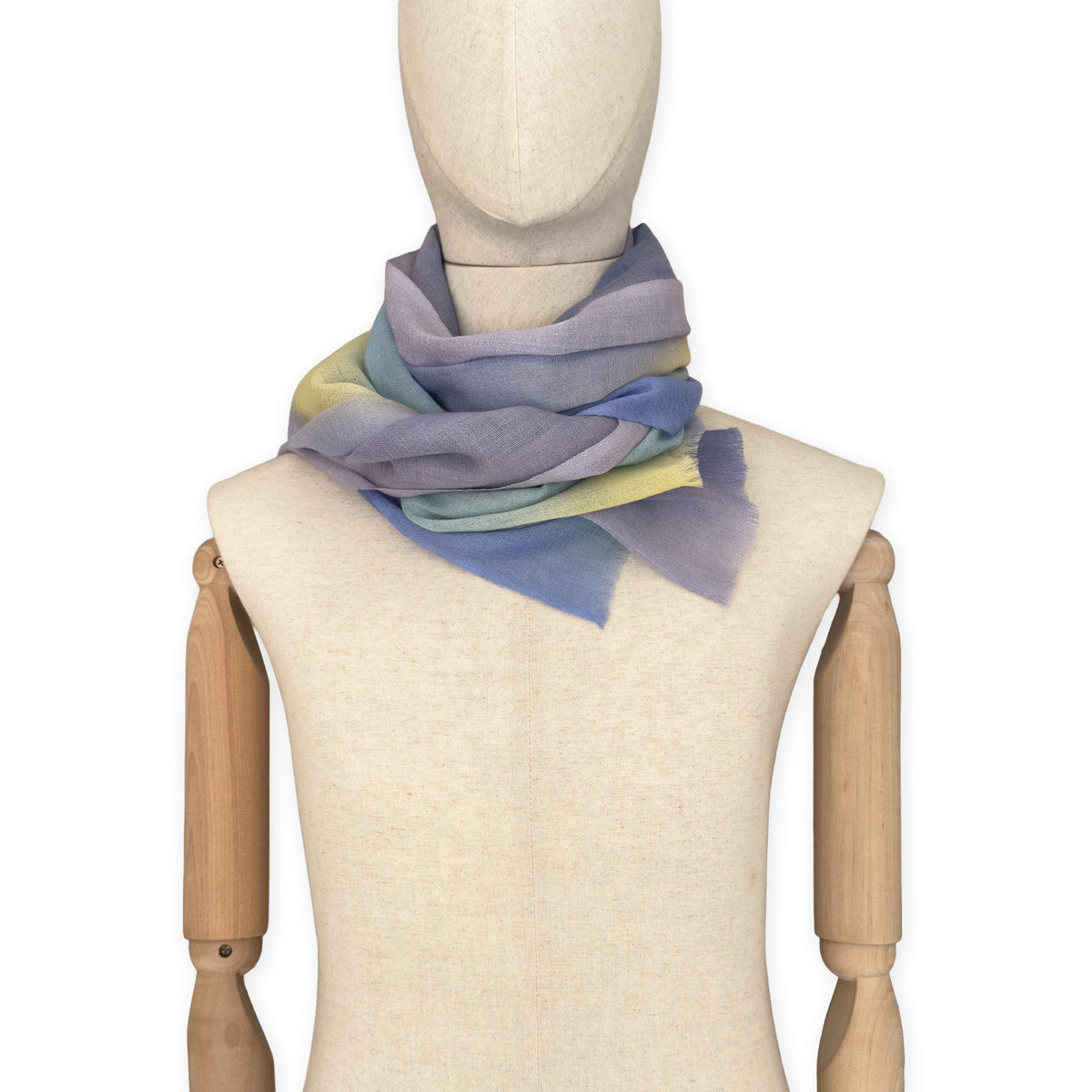 Mannequin wearing scarf on a white background. Hand-painted wool scarf by Otta-Italy, 57 x 180 cm, featuring blue, purple, yellow colors. Luxury Italian accessory, soft and warm scarf for women and men.
