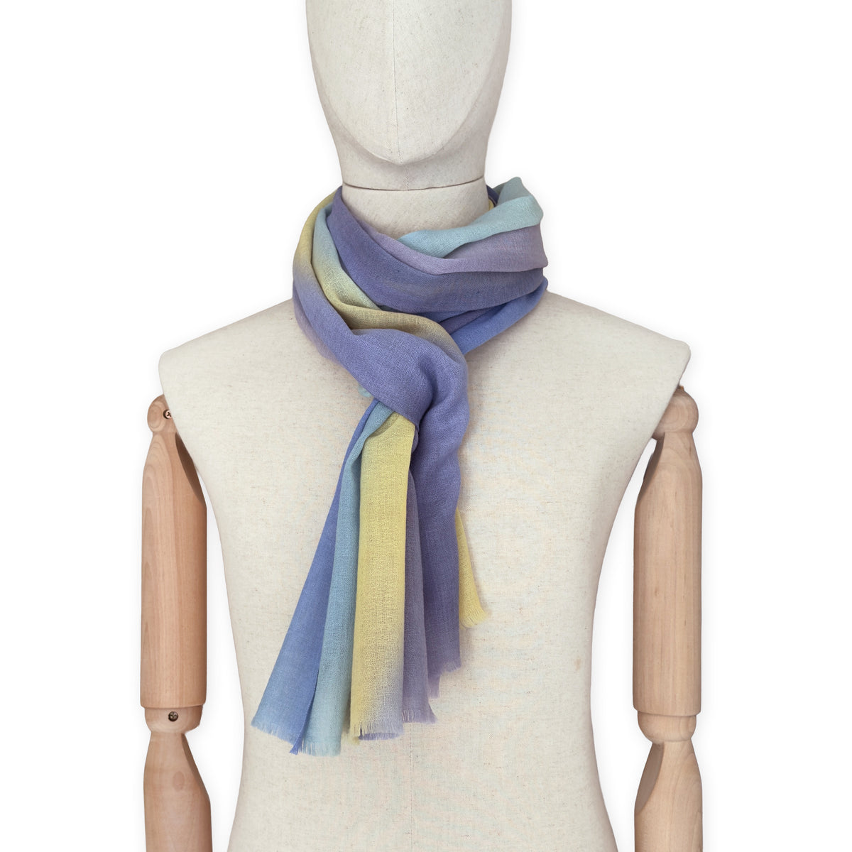 Mannequin wearing scarf on a white background. Hand-painted wool scarf by Otta-Italy, 57 x 180 cm, featuring blue, purple, yellow colors. Luxury Italian accessory, soft and warm scarf for women and men.
