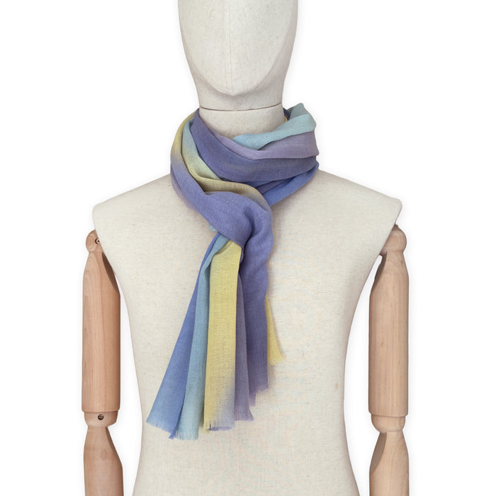 Mannequin wearing scarf on a white background. Hand-painted wool scarf by Otta-Italy, 57 x 180 cm, featuring blue, purple, yellow colors. Luxury Italian accessory, soft and warm scarf for women and men.

