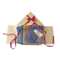Set of scarves in a gift box with a pink ribbon on a white background. 
Hand-painted wool scarf by Otta-Italy, 57 x 180 cm, featuring blue, purple, yellow colors. Luxury Italian accessory, soft and warm scarf for women and men.
