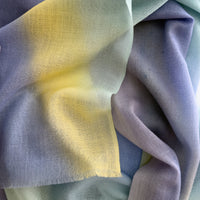Close-up of soft fabric. Hand-painted wool scarf by Otta-Italy, 57 x 180 cm, featuring blue, purple, yellow colors. Luxury Italian mix accessory, soft and warm scarf for women and men.
