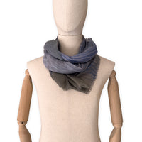 Mannequin wearing an elegant hand-painted Otta wool silk blend scarf on a white background. Blue, gray and brown tones.
