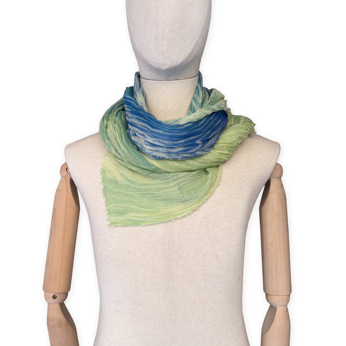 Mannequin wearing scarf on a white background. Hand-painted mix wool and silk scarf by Otta-Italy, 193 x 54 cm, featuring blue, light green and yellow colors. Luxury Italian accessory, soft and warm scarf for women and men.
