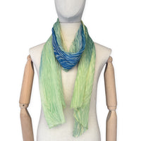 Mannequin wearing scarf on a white background. Hand-painted mix wool and silk scarf by Otta-Italy, 193 x 54 cm, featuring blue, light green and yellow colors. Luxury Italian accessory, soft and warm scarf for women and men.
