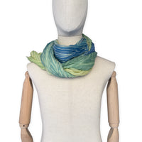 Mannequin wearing scarf on a white background. Hand-painted mix wool and silk scarf by Otta-Italy, 193 x 54 cm, featuring blue, light green and yellow colors. Luxury Italian accessory, soft and warm scarf for women and men.
