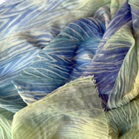 Close-up of soft fabric. Hand-painted mix wool and silk scarf by Otta-Italy, 193 x 54 cm, featuring blue, light green and yellow colors. Luxury Italian mix accessory, soft and warm scarf for women and men.
