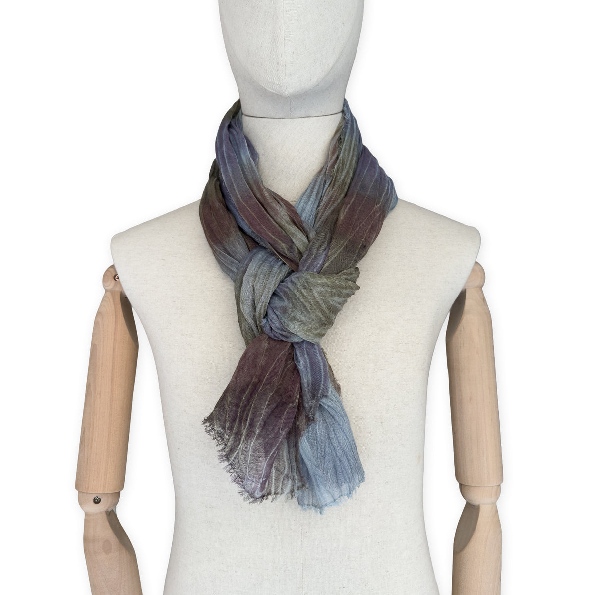 Mannequin wearing scarf on a white background. Hand-painted mix wool and silk scarf by Otta-Italy, 193 x 54 cm, featuring light blue, purple, brown and green colors. Luxury Italian accessory, soft and warm scarf for women and men.
