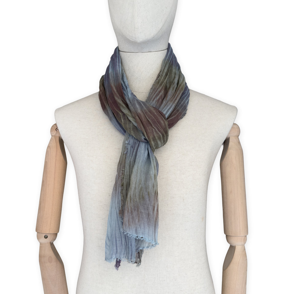 Mannequin wearing scarf on a white background. Hand-painted mix wool and silk scarf by Otta-Italy, 193 x 54 cm, featuring light blue, purple, brown and green colors. Luxury Italian accessory, soft and warm scarf for women and men.
