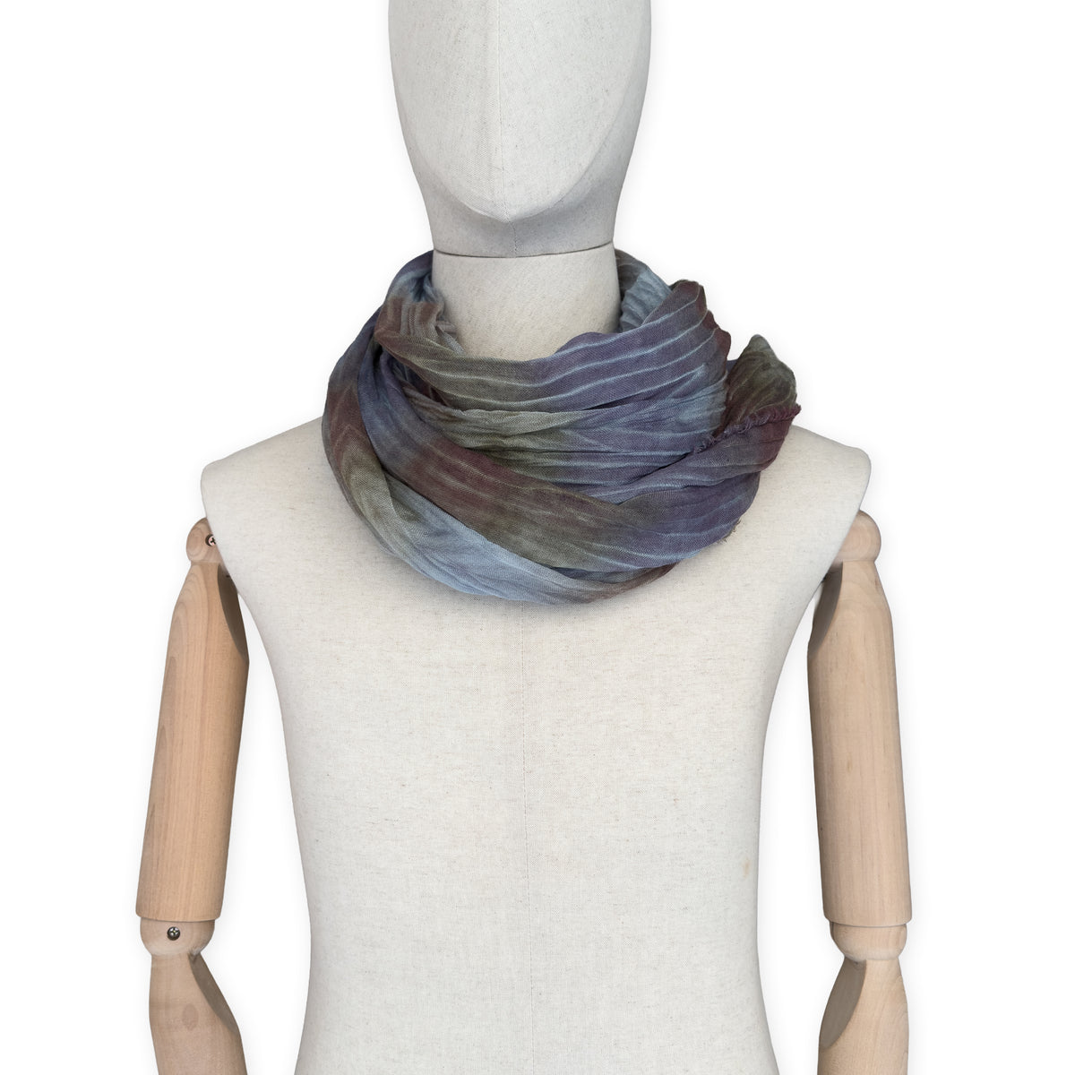 Mannequin wearing scarf on a white background. Hand-painted mix wool and silk scarf by Otta-Italy, 193 x 54 cm, featuring light blue, purple, brown and green colors. Luxury Italian accessory, soft and warm scarf for women and men.
