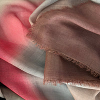 Close-up of soft fabric. Hand-painted mix wool and silk scarf by Otta-Italy, 67 x 198 cm, featuring brown, gray and red colors. Luxury Italian mix accessory, soft and warm scarf for women and men.
